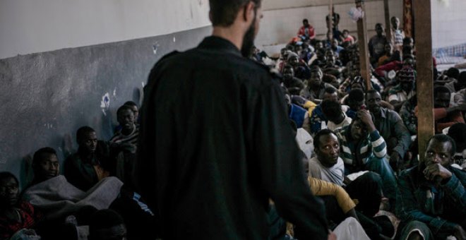 Un militar libio custodia a cientos de personas encerradas en una centro de detención de inmigrantes de Libia-. MSF