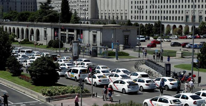 Un grupo de taxis permanecen concentrados a su paso por el ministerio de Fomento. /EFE