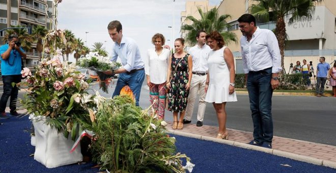El presidente del PP, Pablo Casado (1i), deposita hoy un ramo de flores en el monolito que recuerda a las dos personas asesinadas por ETA , entre ellos una niña de 6 años, en un atentado contra la casa cuartel de Santa Pola en agosto de 2002. En la visita