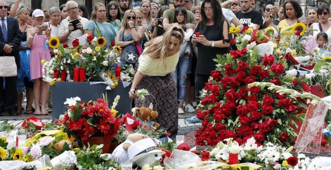 Grupo de personas depositan flores en el mosaico de Miró en Las Ramblas en recuerdo de las victimas de los atentados del 17-A. - EFE