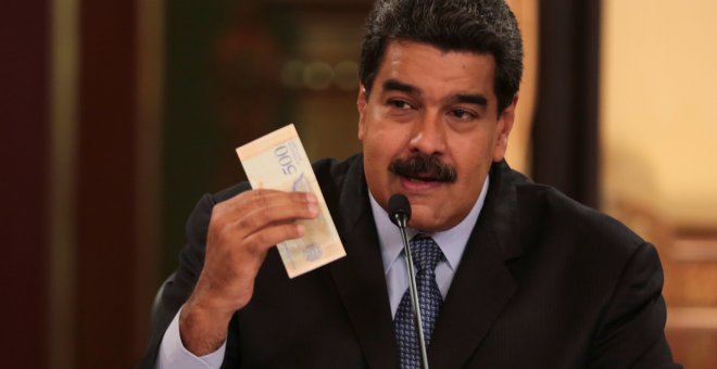 El presidente de Venezuela, Nicolas Maduro, sujeta un billete de banco de la nueva divisas del país, el Bolivar Soberano, durante la presentación de las nuevas medidas económicas, en el Palacio de Miraflores, en Caracas. REUTERS
