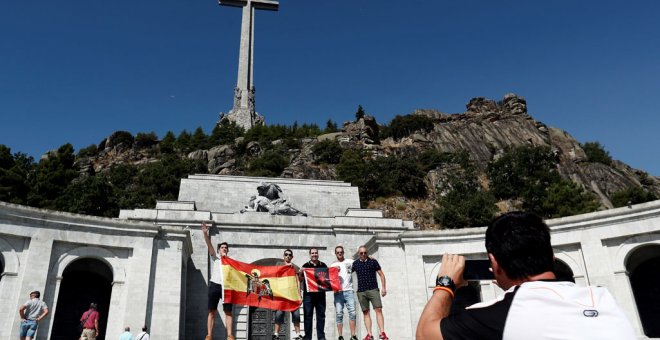Un grupo de personas con una bandera anticonstitucional y otra de la Falange se fotografía en la explanada del Valle de los Caídos.EFE/Mariscal