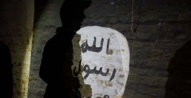 La sombra de un hombre armado vista sobre una pintada con el símbolo del Estado Islámico.REUTERS/Alaa al-Marjani