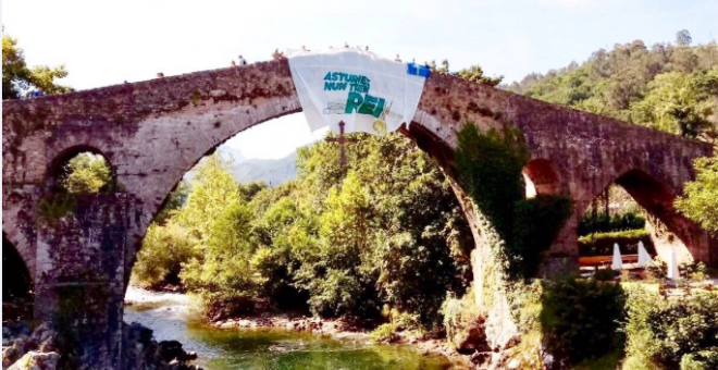 La pancarta en el puente romano de Cangas de Onís en contra de la presencia de los reyes. | Facebook de Lluchando Pola Soberanía
