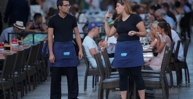 Dos camareros charlan en una terraza de un restaurante de la localidad malagueña de Ronda. REUTERS/Jon Nazca