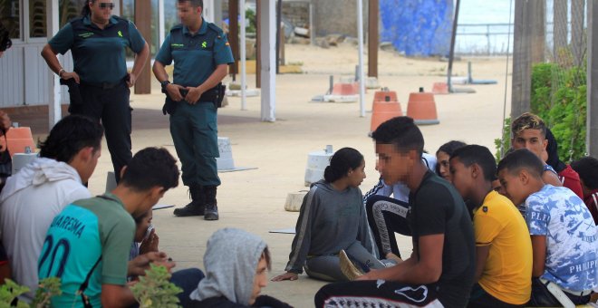 Menores esperando en la playa de Bolonia enTarifa (Cádiz) tras ser rescatados en un patera en aguas del Estrecho de Gibraltar - EFE/ A.Carrasco Ragel