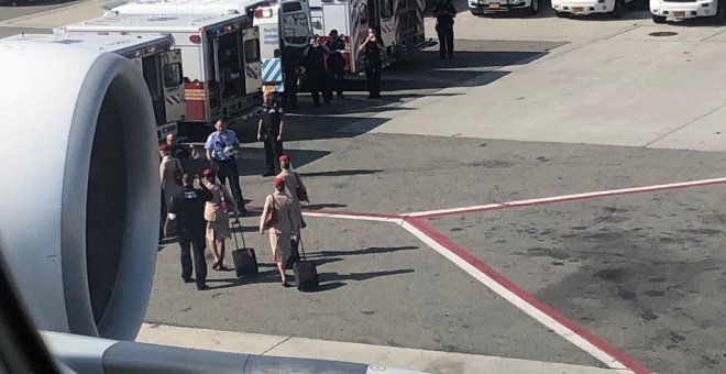Ambulancias situadas en la pista de aterrizaje, al lado del avión puesto en cuarentena en el aeropuerto JFK de Nueva York. /REUTERS