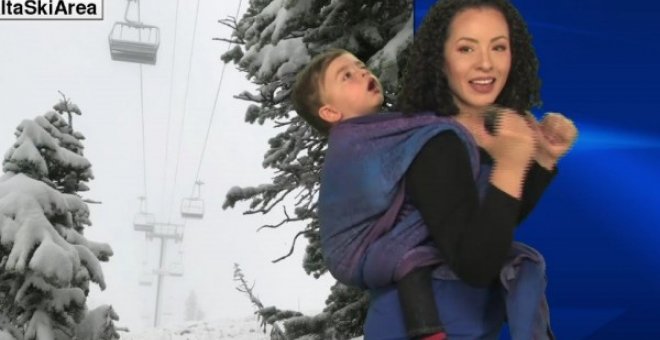 La presentadora Susan Martin con su hijo a la espalda dando el parte meteorológico. Fuente: facebook.