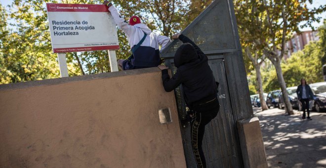 Dos menores migrantes saltan el muro para acceder al Centro de Primera Acogida de Menores de Hortaleza, en Madrid.- JAIRO VARGAS