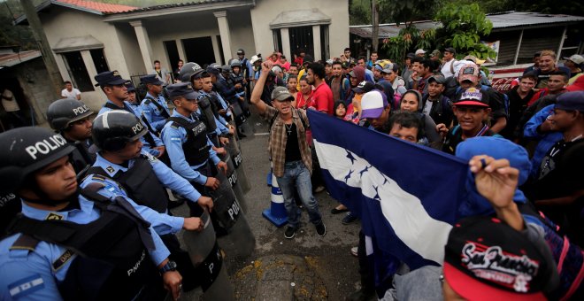 Migrantes hondureños se paran frente a policías hondureños bloqueando el acceso a Agua Caliente. REUTERS/Jorge Cabrera