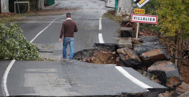 Un hombre camina por una carretera dañada tras las inundaciones provocadas por las fuertes lluvias en el departamento de Aude, en Conques (Francia). EFE