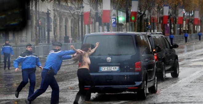 Una activista de Femen, detenida antes de alcanzar el coche de Trump en la ceremonia del Armisticio. REUTERS/Carlos Barria