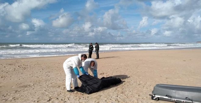 Operarios trasladan el cuerpo de uno de los migrantes del naufragio de la patera ocurrido el 5 de noviembre en Caños de Meca (Cádiz). / EFE