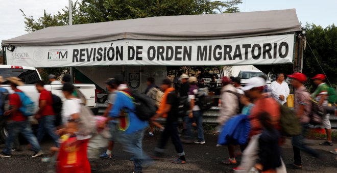 Migrantes de la caravana que viaja hacia EEUU pasan por un punto de revisión de orden migratorio. REUTERS/Carlos Garcia Rawlins