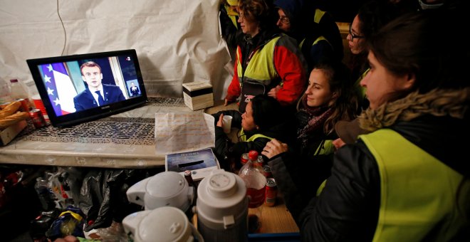 Miembros del movimiento conocido como 'chalecos amarillos' observan el discurso del presidente de Francia, Emmanuel Macron. - EFE