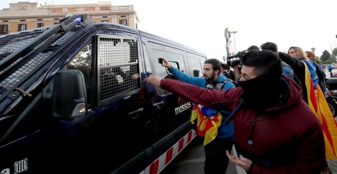 Simpatizantes independentistas ante el paso de una furgoneta de los Mossos d'Esquadra, en las inmediaciones de la Llotja de Mar de Barcelona | Alberto Estevez / EFE