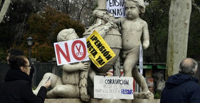 Una estatua del centro de Madrid con las pacartas y carteles de una manifestación de jubilados demandando mejores pensiones. AFP/Javier Soriano