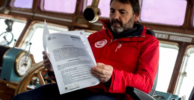 El fundador de la ONG Open Arms, Oscar Camps , lee el despacho enviado por el Ministerio de Fomento, que les deniega el permiso para zarpar hacia el Mediterráneo.EFE/ Quique García