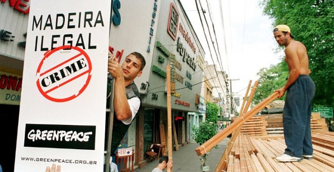 Un activista coloca un cartel que denuncia la extracción ilegal de madera en el Amazonas. AFP/MARIE HIPPENMEYER