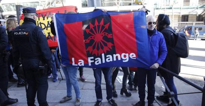 Un hombre sujeta una bandera de La Falange, en la concentración en contra de lo procesados por el juicio del Procés en el Tribunal Supremo. Eduardo Parra Europa Press