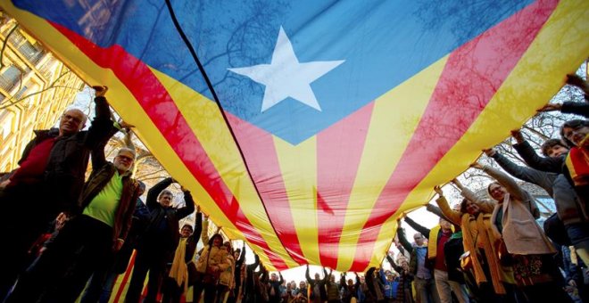 Manifestantes portan una gran estelada durante la movilización. EFE/Enric Fontcuberta