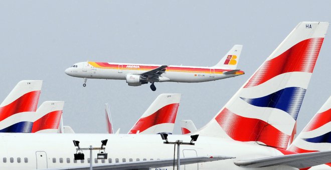 Un avión Airbus 321 de Iberia pasa junto a otros aparatos de British Airways, en su maniobra de aterrizaje en el aeropuerto londinense de Heathrow. REUTERS/Toby Melville