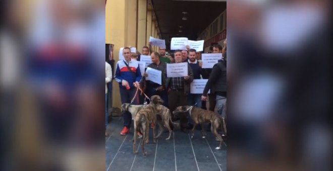 Un grupo de cazadores protesta frente a un puesto de Pacma de recogida de avales electorales en Badajoz.