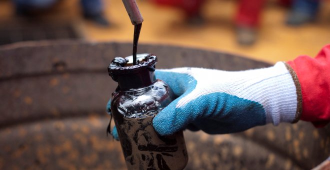 Un trabajador toma una muestra de petróleo en un pozo operado por la compañía petrolera estatal PDVSA en Morichal, Venezuela. REUTERS/Carlos Garcia Rawlins