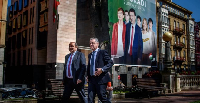 El lehendakari Iñigo Urkullu y el presidente del PNV, Andoni Ortuzar, caminan delante del cartel electoral de su formación. | EFE