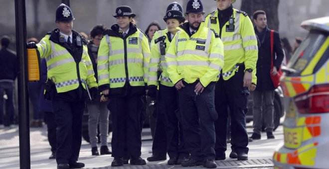 Agentes de policía se disponen a cruzar una calle ante el Parlamento británico. Reuters