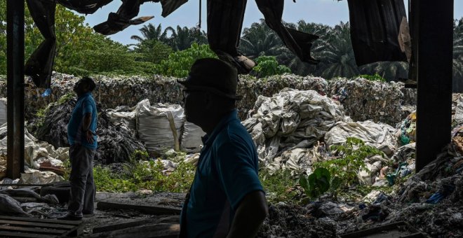 Voluntarios de una(ONG) se encuentran cerca de los desechos plásticos en una fábrica abandonada en Jenjarom, un distrito de Kuala Langat, en las afueras de Kuala Lumpur. MOHD RASFAN / AFP