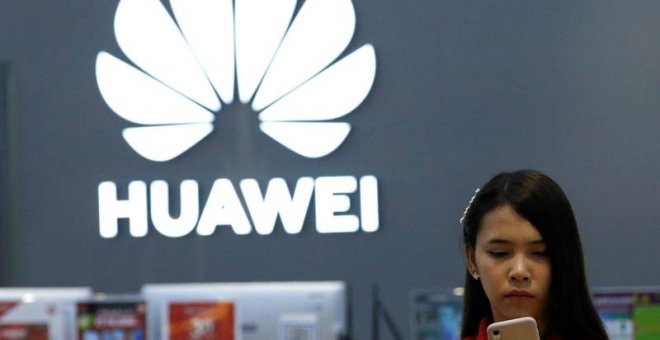 21/05/2019.- Una empleada revisa un teléfono Huawei en una tienda de la marca en Bangkok (Tailandia), este martes. Huawei restó este martes importancia a que las restricciones estadounidenses vayan a afectar a sus productos o al despliegue de la tecnologí