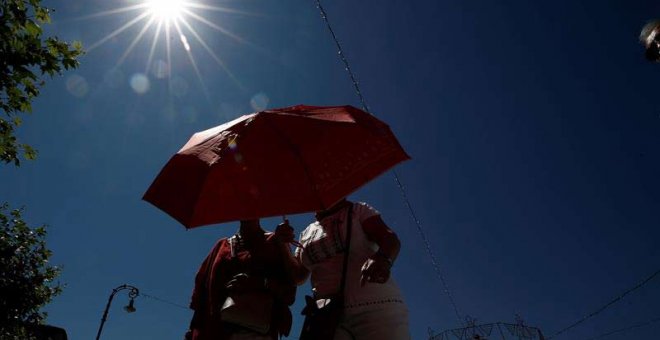Dos mujeres se protegen con un paraguas de sol en Pamplona. (JESÚS DIGES | EFE)