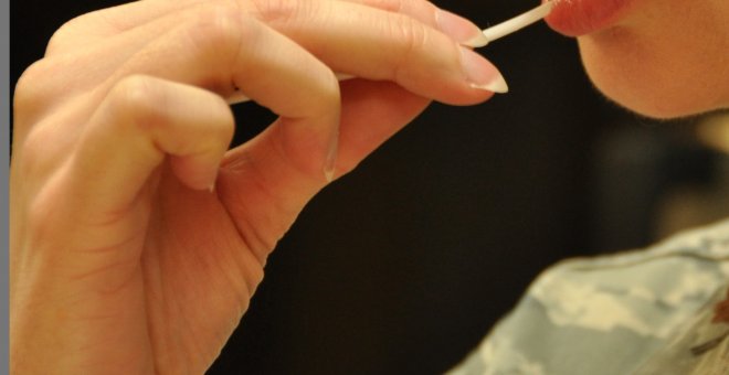 Una mujer toma una muestra de sui ADN con un frotis bucal. Foto: Travis Air Force Base