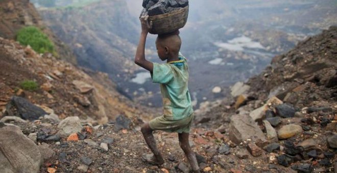 Un niño carga carbón a través de los campos del este del Estado de Jharkhand, en la india.- REUTERS/ARCHIVO