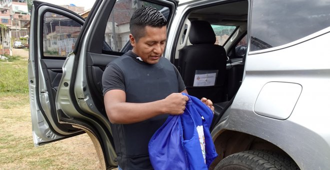 El líder indígena Edwin Mauricio Capaz se coloca un chaleco antibalas antes de montarse en su coche blindado. / Reuters
