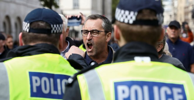 Un ciudadano grita a dos policías durante una manifestación en la avenida Whitehall de Londres. /REUTERS