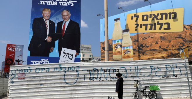 16/09/2019 - Un judío ortodoxo mira un cartel de la campaña que muestra al primer ministro israelí Benjamin Netanyahu y al presidente estadounidense, Donald Trump. / REUTERS - AMMAR AWAD