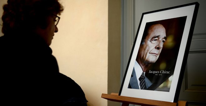 Una mujer frente a un retrato del expresidente francés Jacques Chirac.- AFP