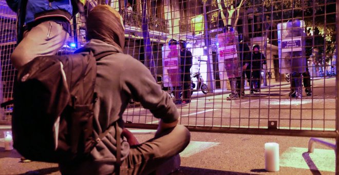 Manifestantes de los CDR, sentados pacíficamente con velas encendidas ante las vallas que después derribarían los infiltrados, provocando incidentes y cargas policiales. SERGI CAMARA