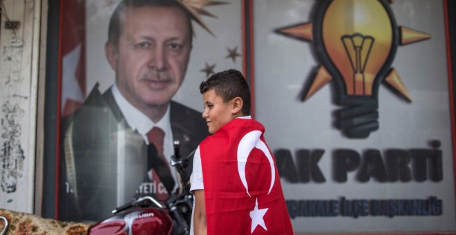 Un niño con una bandera turca frente a un retrato del presidente Recep Tayyip Erdogan cerca de la frontera siria, en el Sanliurfa, el distrito de Akcakale. EFE / EPA / ERDEM SAHIN