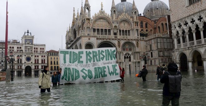 Varias personas sujetan una pancarta en la que se lee "La  marea está subiendo y así estamos". EFE/Andrea Merola