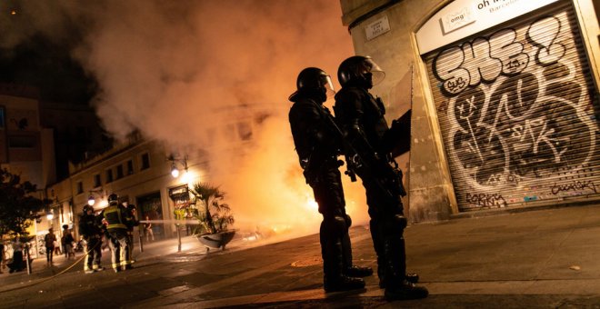 Dos antidisturbios de los Mossos d'Esquadra, apostados en una esquina tras las cargas policiales en Barcelona el pasado 18 de octubre.-EFE