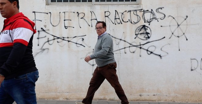 Vecinos de Torre-Pacheco (Murcia) caminan frente a unas pintadas a favor y en contra de la extremada derecha, que ha arrasado en las elecciones generales en la localidad. ENTREFRONTERAS