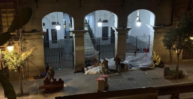 Imagen de varias personas durmiendo frente a las puertas de la sede del Samur Social. / EUROPA  PRESS