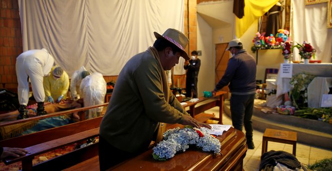 Un hombre deja flores sobre el ataúd de uno de los muertos en durante los enfrentamientos en la planta de gas de Senkata, en la ciudad de El Alto, Bolivia.-  REUTERS/David Mercado