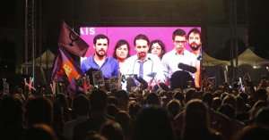 Simpatizantes de Unidos Podemos escuchan las declaraciones de su líder Pablo Iglesias (c. en la pantalla) durante su comparecencia ante la prensa tras conocer los resultados de las elecciones generales celebradas en España, hoy en la plaza del museo Reina