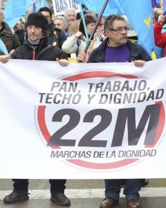 Dos participantes en las Marchas por la Dignidad tras una de las pancartas en la Plaza de Colón. EFE/Ballesteros