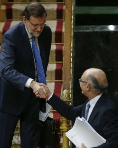 El presidente del Gobierno, Mariano Rajoy, felicita al ministro de Hacienda, Cristóbal Montoro, tras la intervención de éste ante el pleno del Congreso para defender los Presupuestos Generales del Estado para 2016. EFE/Paco Campos