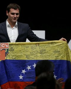 El líder de Ciudadanos, Albert Rivera, sostiene una bandera venezolana firmada durante el cierre de campaña para las elecciones del 20-D en Madrid. REUTERS/Andrea Comas